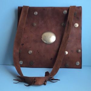 Handmade two-pouch leather flat bag with metal & coin decorations.